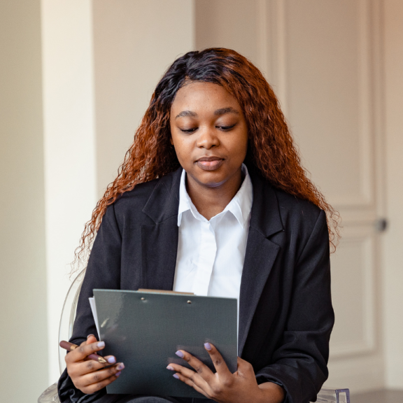 female therapist in a blazer looking down at notebook