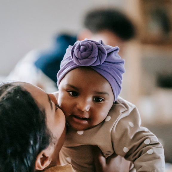 mother kissing baby daughter on cheek