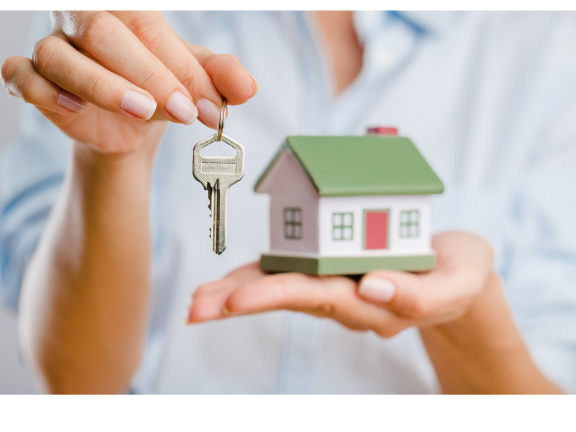 hand holding tiny house and key