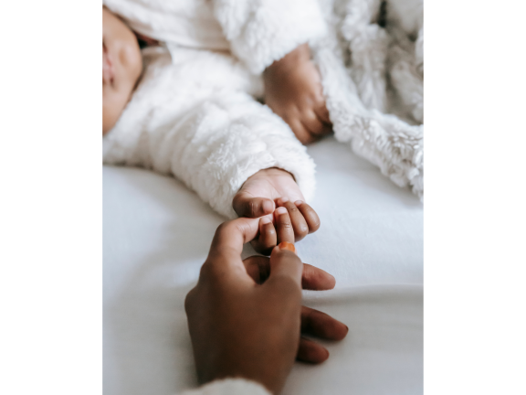 mother holding infant's hand